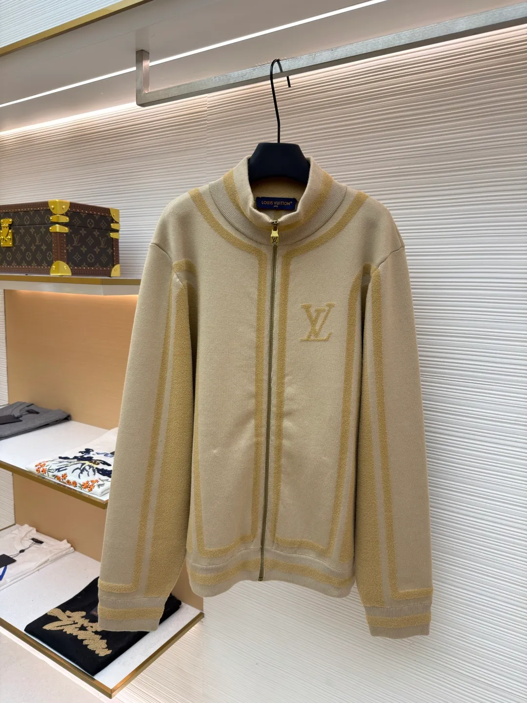 LOUIS VUITTON two-color splicing intarsia zipper jacket ●Original version: purchased and developed at 20700 ●Item number: 1681968-C15 ●Fabric: nylon fabric ●Technology: intarsia production ●Color: khaki ●Version: fitted version ●Weight: about 1020 grams ●Size: XS-S-M-L ●Description: Made of 43% nylon, 32% cotton and 25% viscose blended fabric, which has both comfort and stiffness. The designer used two-tone intarsia technology to allow contrasting color strips to run through the sleeves and body, forming a smooth visual extension. Different areas create subtle three-dimensional texture effects by changing knitting density and stitching methods. The chest is decorated with a delicate intarsia LV logo, and the Vuitton word is presented in elegant font on the back, showing brand recognition in every detail. The collar, cuffs and hem made of rib knitting technology not only enhance the stability of the silhouette, but also echo the overall design language. The front placket features a smooth zipper closure and practical slip pockets on both sides for added functionality. The entire piece perfectly interprets the exquisite aesthetics of sports and leisure style through the ingenious combination of fabric texture and craftsmanship details. The overall wiring is straight and delicate, the fabric is comfortable and soft, and the color is consistent without color difference. It can be matched with the same style to create a fashionable look and control various occasions. Customized accessories, complete with three standards, same style for men and women!